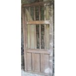An antique oak architectural panel or door, partially open with moulded vertical doors, 236cm high x