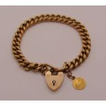 15ct curb link bracelet with heart padlock clasp, hung with an 18ct St Anne d'Auray charm, 19.6g