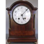 An inlaid Edwardian mahogany mantel clock, with brass column supports, convex enamel dial and two