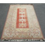 A Middle Eastern style carpet, with a central panel containing a medallion, in pale hues of