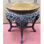A 19th century Chinese hardwood occasional table, the circular top raised on four carved supports,