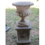 A small weathered cast composition stone garden urn, the circular lobed bowl with flared egg and