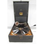 A HMV early 20th century wind up gramophone in working order, and a single record.