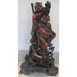 A Chinese hardwood carving of two men carousing together with a wine vessel and dog in the
