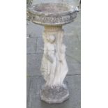A weathered cast composition stone bird bath, the circular bowl with repeating leaf band, raised