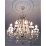 A substantial contemporary chandelier with twelve branches, pear cut and other shaped drops, further