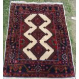 A Persian Shiraz rug with a thick pile with three interlocking medallions to the central panel and