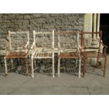 A set of four old iron strapwork garden chairs, with entwined and scrolled backs and lattice seats