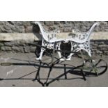 A vintage painted ironwork wheelbarrow chassis with single twisted spoke wheel together with a