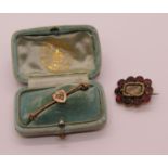 Georgian mourning brooch set with flat-cut garnets and a further yellow metal shield brooch set with