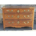A late 18th century French provincial walnut commode of three drawers, with original brass fittings,