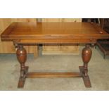 An early 20th century oak drawer leaf refectory dining table with moulded frieze raised on a pair of