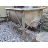 A vintage galvanised steel dairy trough of rectangular and rounded form, raised on angular supports,