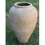 A vintage terracotta olive jar with simple incised bands and combed detail, 60cm high approx