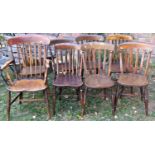 A harlequin set of six Windsor stained elm and beechwood lathe back kitchen chairs raised on