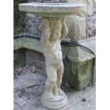 A weathered cast composition stone two sectional bird bath, the pedestal in the form of a standing
