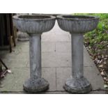 A pair of painted and weathered cast composition stone garden planters with circular fluted bowls
