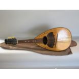 An eight string Mandolin , missing four strings, with a canvas bag.