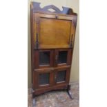 An arts and crafts oak bureau, the fall front over two pairs of glazed panel doors, with original