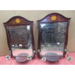 A pair of Edwardian mahogany wall mirrors, each supporting a pair of brass candle scones, with shell