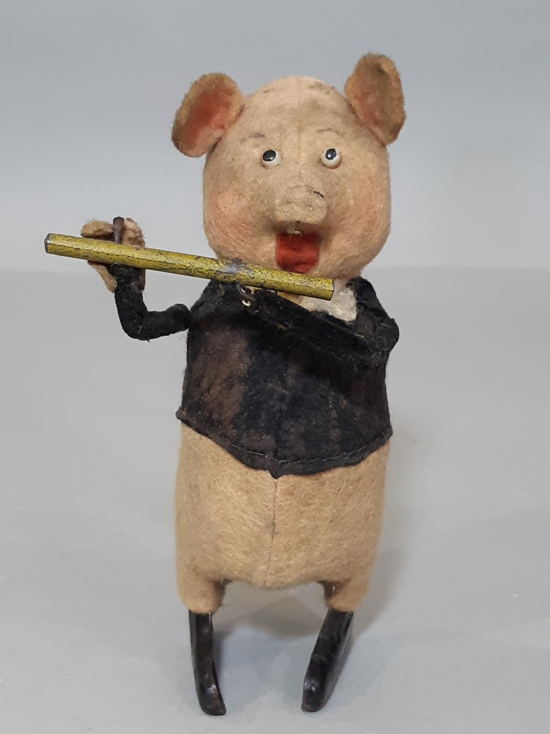 A Schuco clockwork toy in the form of a pig playing a flute, height 11cm, no key