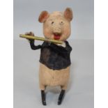 A Schuco clockwork toy in the form of a pig playing a flute, height 11cm, no key