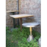 Two café or bistro tables of varying size and design, both with stripped wooden tops, together
