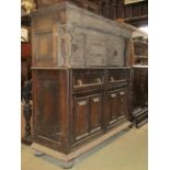 An antique old English style oak court cupboard enclosed by an arrangement of cupboards and