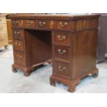 A Georgian style mahogany kneehole twin pedestal writing desk with inset mint green coloured writing
