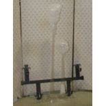An old English style hammered steel wall rack supporting two graduated glass yard of ale measures