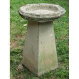 A weathered cast composition stone bird bath of octagonal form with script, 40 cm diameter raised on