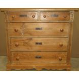 A stripped pine bedroom chest of two short over three long drawers flanked by reeded and carved