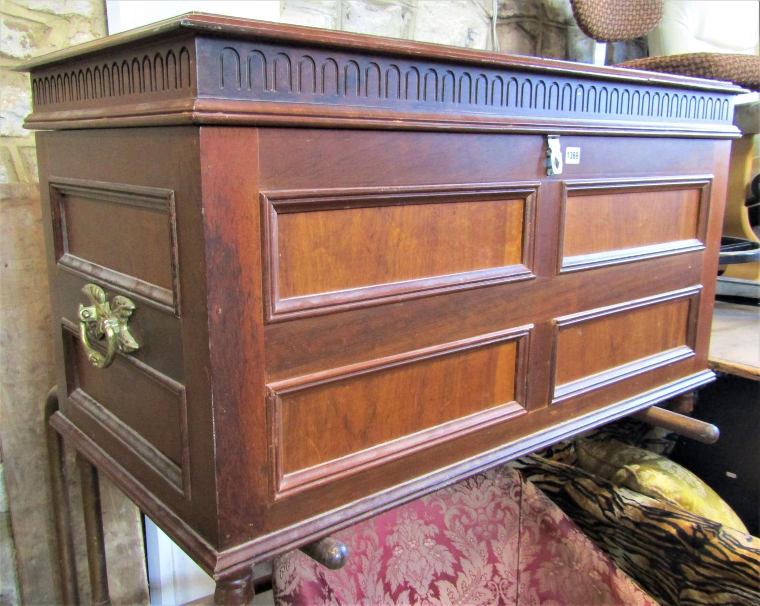 A walnut coffer with rectangular moulded panelled surround beneath a hinged lid with repeating