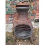 A weathered contemporary cast iron pot bellied chimenea raised on swept supports, 70 cm high