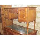 An oak kneehole dressing table with central frieze drawer flanked by cupboards enclosed by fielded