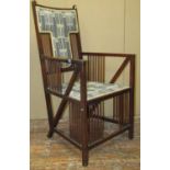 An arts and crafts elbow chair in mahogany with stick back, sides and low rails, with upholstered