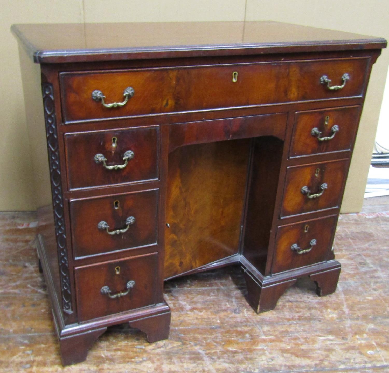 An Edwardian mahogany kneehole writing desk or dressing table in the Georgian style, the central