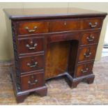 An Edwardian mahogany kneehole writing desk or dressing table in the Georgian style, the central