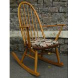 An Ercol light elm and beechwood hoop and stick back rocking chair with open swept arms