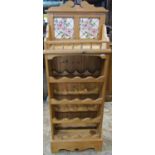 A stripped pine kitchen floorstanding wine rack to hold sixteen bottles, with galleried shelf and
