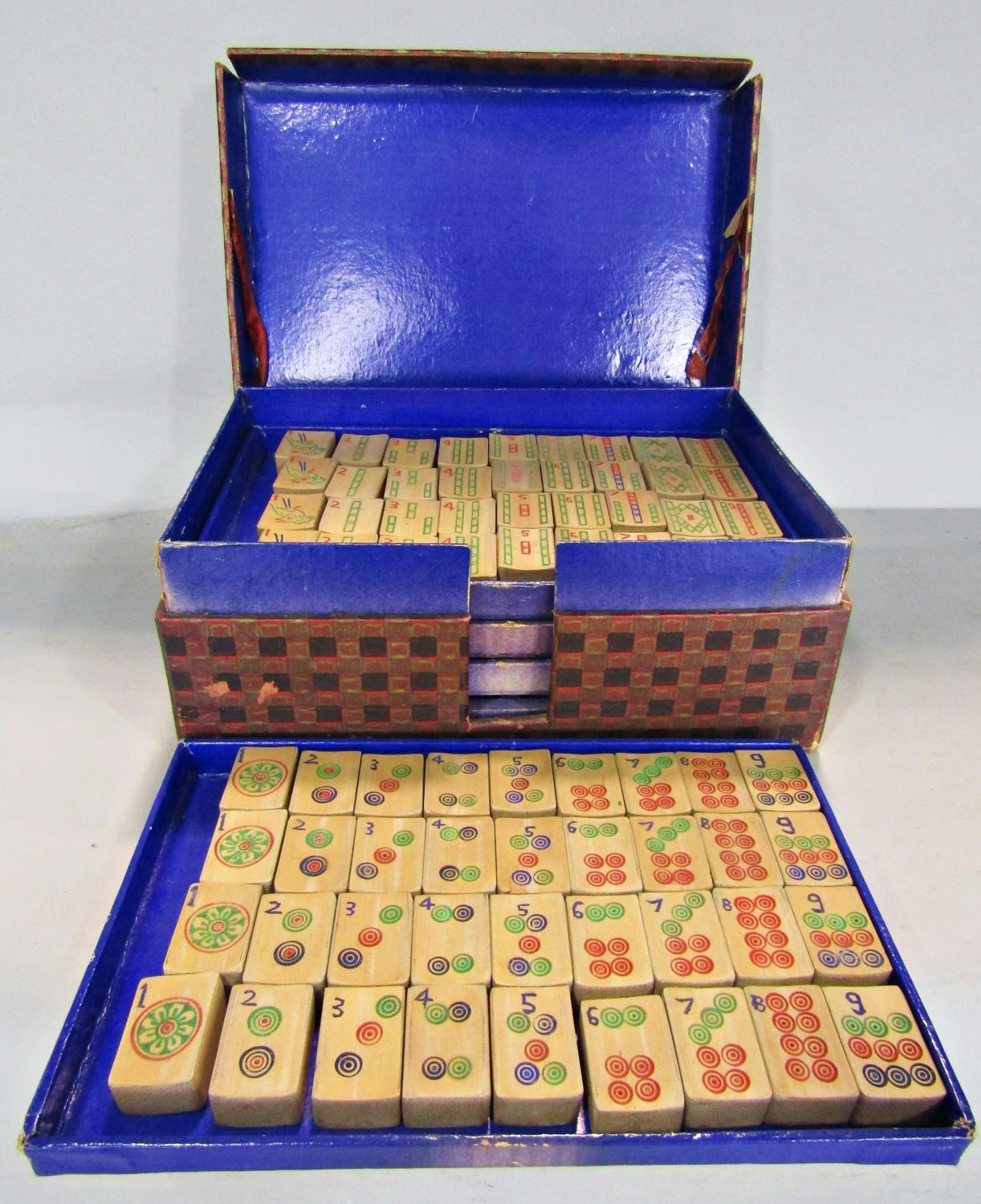 A complete set of Mahjong with bamboo tiles set over five trays in a cardboard box.