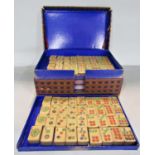 A complete set of Mahjong with bamboo tiles set over five trays in a cardboard box.