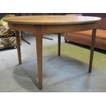 A mid 20th century teak D end pull out extending dining table with single additional bi-fold leaf