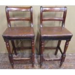 A pair of 19th century shop or workshop chairs with bar backs and hide upholstered seats on turned