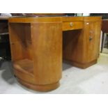 An Art Deco style satinwood veneered kneehole desk with shallow inverted breakfront incorporating