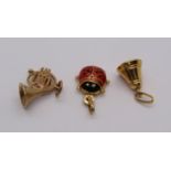 Three 9ct charms comprising an enamelled ladybird, a French horn and a bell, 3.6g total