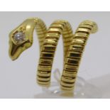 Yellow metal novelty ring in the form of a coiled snake, the head set with a 0.15ct diamond,