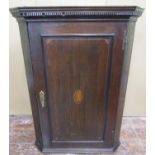 A Georgian oak hanging corner cupboard enclosed by a single panelled door with shell detail, beneath