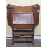 An arts and crafts oak bureau with fall front over a single frieze drawer with open shelves below,