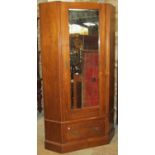 An Edwardian walnut floorstanding corner wardrobe with moulded architectural cornice over a three